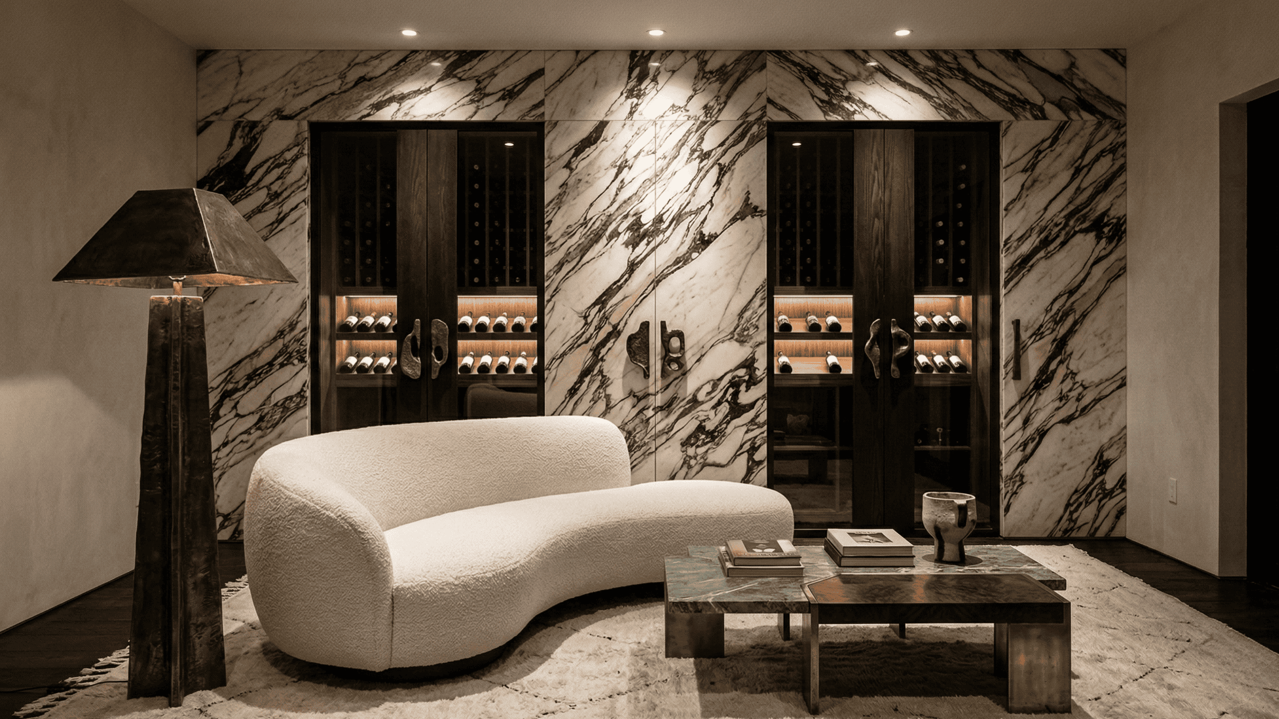 Dramatic luxury wine storage wall featuring breathtaking bookmatched marble integration, dark oak cabinetry, and warm LED accents. High-end architectural millwork in West Vancouver.